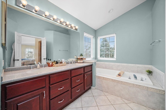 ensuite bathroom with a sink, lofted ceiling, tile patterned flooring, and connected bathroom