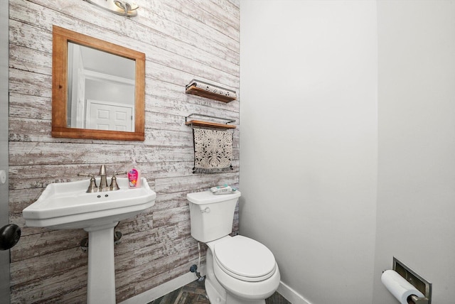half bathroom with toilet and baseboards