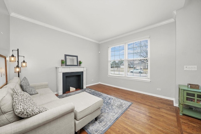 living room featuring a fireplace with flush hearth, wood finished floors, and crown molding