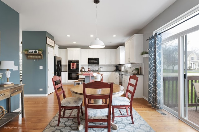dining room with light wood finished floors, baseboards, and recessed lighting