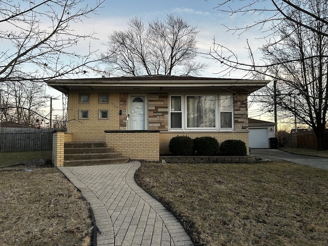 bungalow-style home with a garage, brick siding, a front yard, and fence