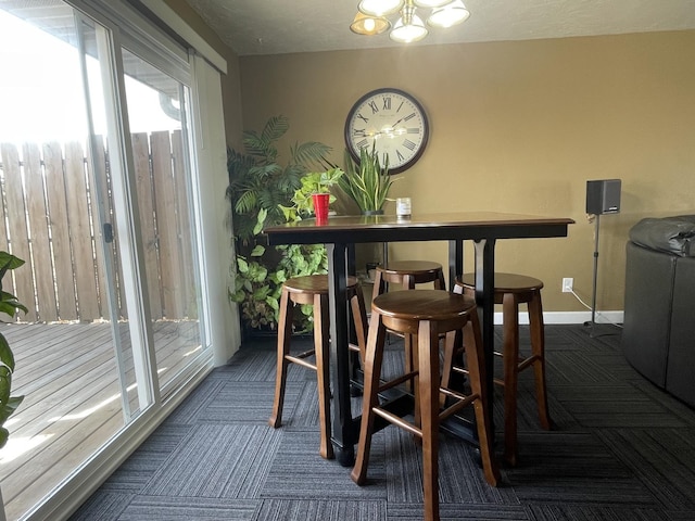 carpeted dining room with baseboards