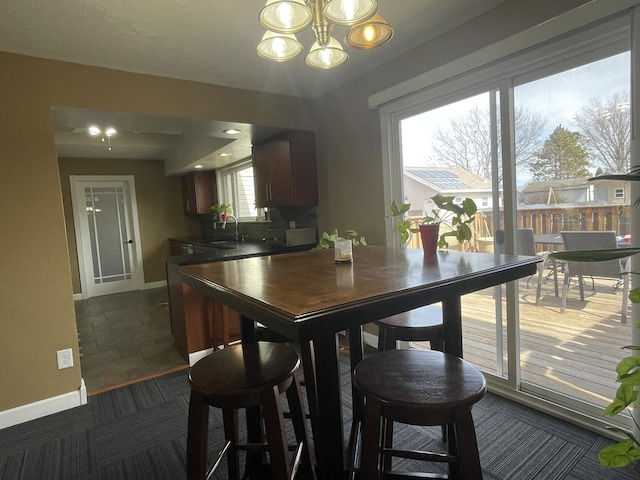 dining space with baseboards and an inviting chandelier