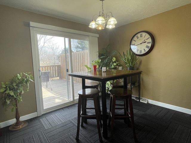 dining area featuring a notable chandelier, baseboards, and dark colored carpet