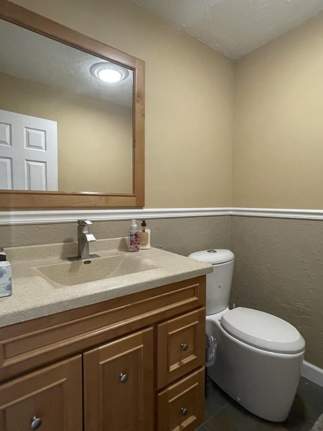 bathroom featuring toilet and vanity