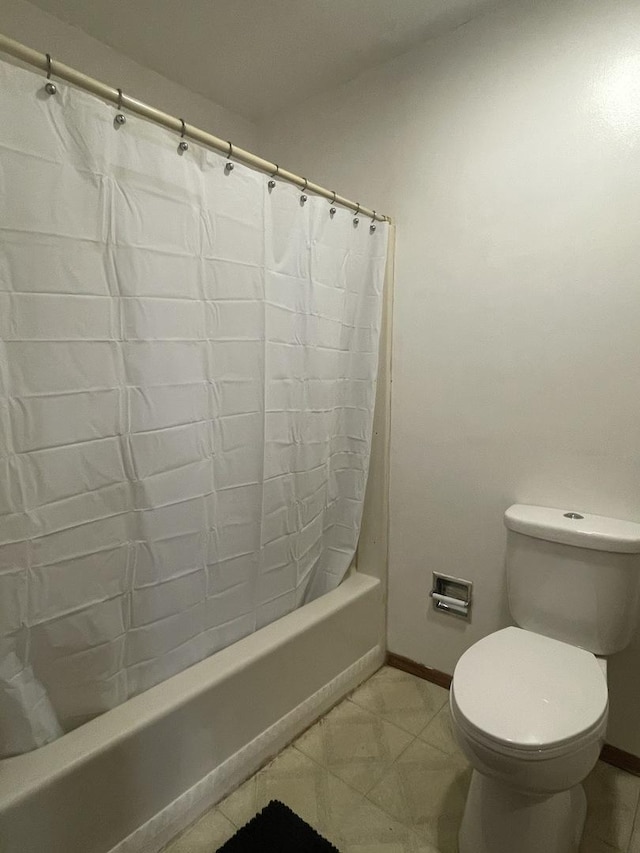 full bathroom with tile patterned flooring, toilet, baseboards, and shower / bathtub combination with curtain