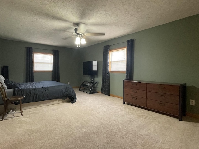 bedroom with light colored carpet, a textured ceiling, and ceiling fan