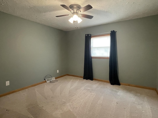 unfurnished room with baseboards, light colored carpet, a ceiling fan, and a textured ceiling