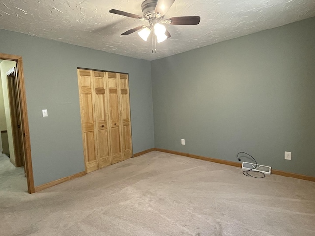 unfurnished bedroom with a closet, baseboards, a textured ceiling, and carpet flooring