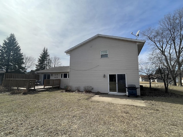 rear view of property featuring a patio, a deck, and fence