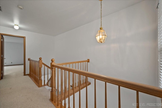 109 Oxford Ct Unit 0, Oswego, IL 60543 - hall with an upstairs landing, light carpet, and a chandelier