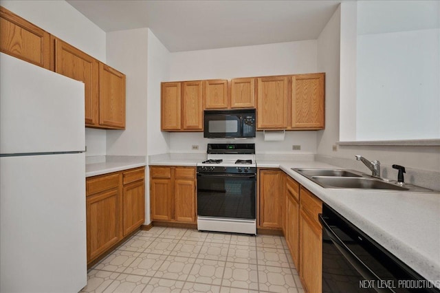109 Oxford Ct Unit 0, Oswego, IL 60543 - kitchen featuring black appliances, a sink, light countertops, light floors, and brown cabinetry