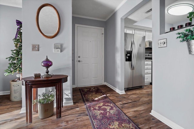 entryway featuring visible vents, baseboards, dark wood-type flooring, and crown molding