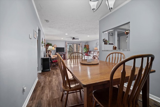 dining space with dark wood finished floors, a textured ceiling, baseboards, and ornamental molding