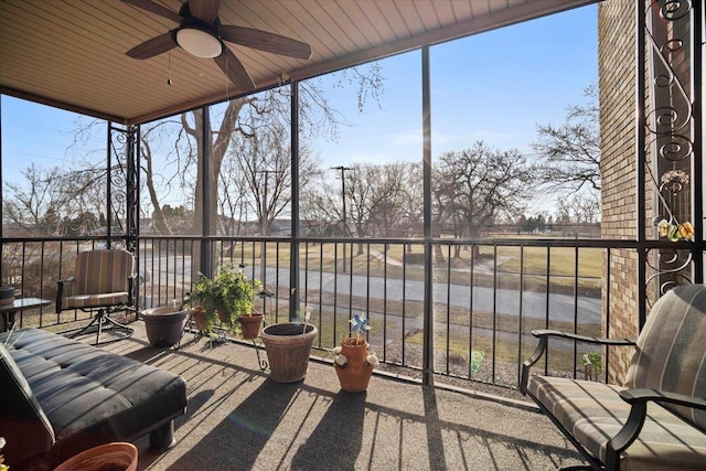 unfurnished sunroom with wood ceiling and a ceiling fan