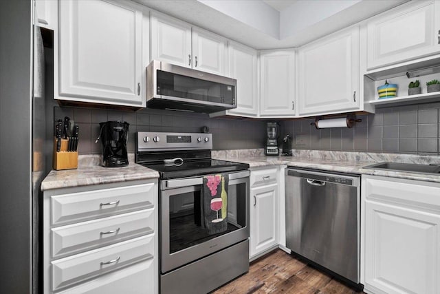 kitchen with stainless steel appliances, tasteful backsplash, dark wood-style flooring, and white cabinetry