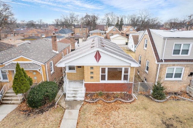 view of front of house featuring a residential view, brick siding, and fence