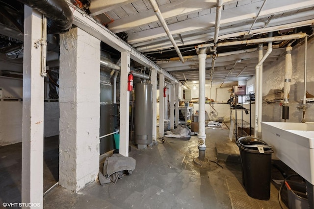 unfinished basement with gas water heater and a sink