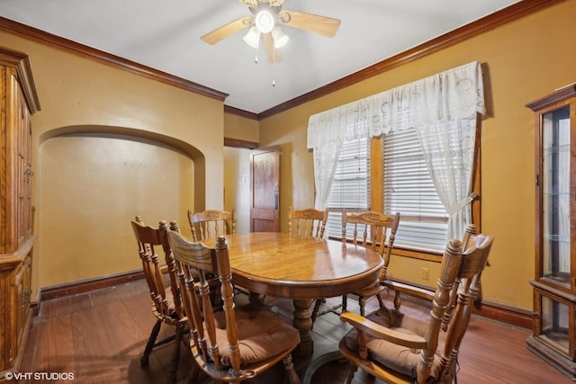 dining room featuring a ceiling fan, wood finished floors, baseboards, and ornamental molding