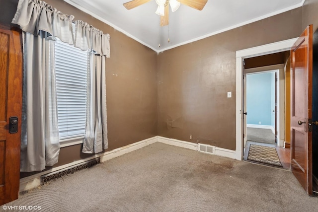 spare room featuring visible vents, ceiling fan, baseboards, carpet, and ornamental molding