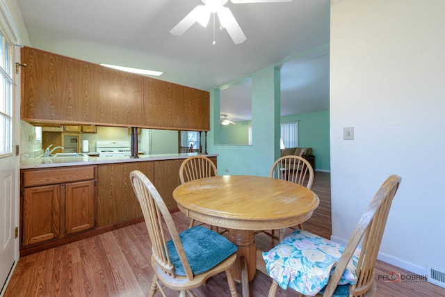 dining space with light wood finished floors, visible vents, baseboards, and ceiling fan