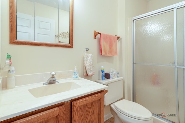 bathroom with a shower stall, vanity, and toilet