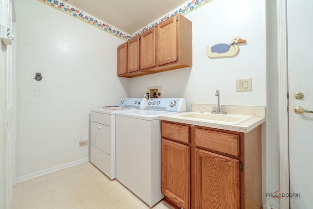 clothes washing area with a sink, washer and dryer, cabinet space, baseboards, and light floors