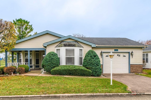 view of front facade featuring driveway, a porch, a front yard, a garage, and brick siding