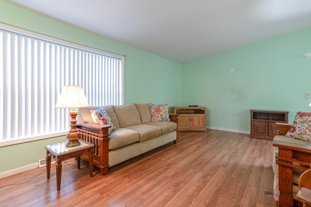 living area featuring light wood finished floors, visible vents, and baseboards