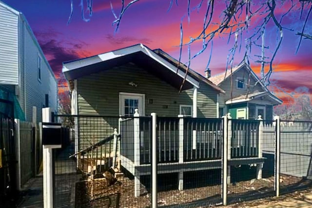 back of property at dusk featuring fence