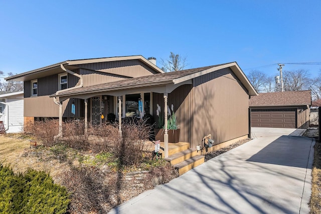 view of front of property with a garage, an outbuilding, covered porch, and roof with shingles