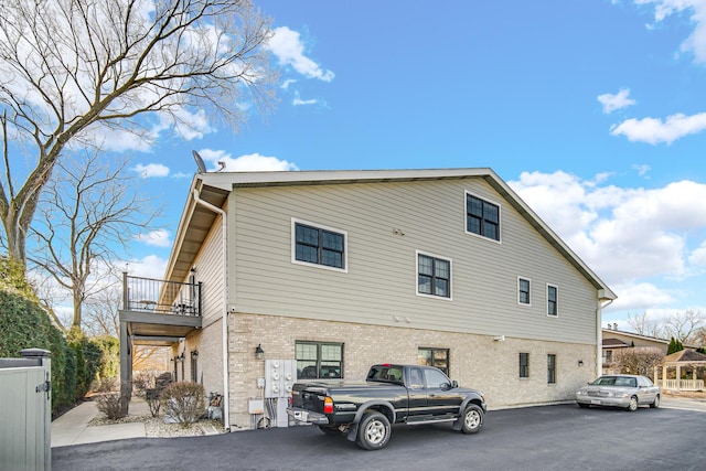 view of home's exterior featuring brick siding and a balcony