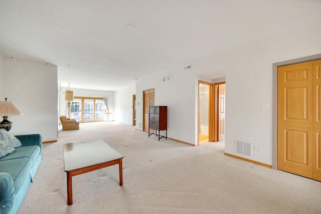 living room with carpet, visible vents, and baseboards