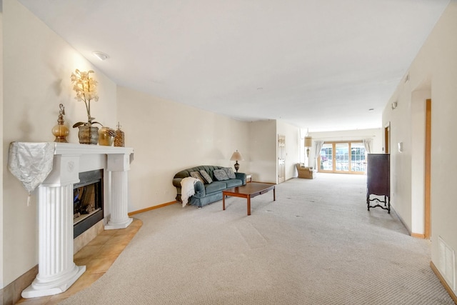 living room featuring baseboards, visible vents, decorative columns, a fireplace, and light carpet