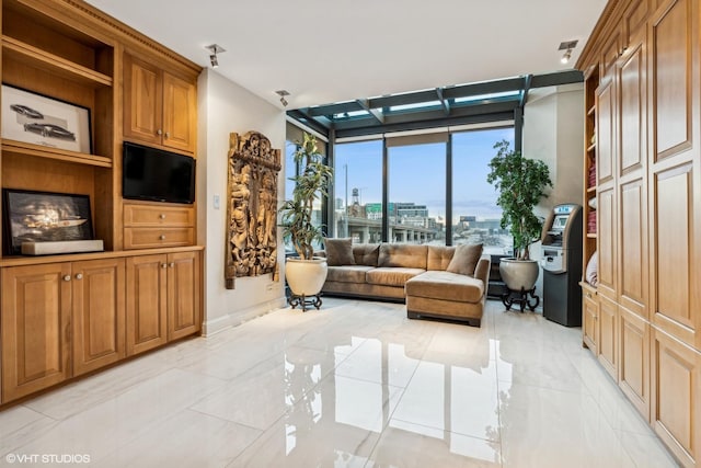 sitting room featuring a wall of windows and baseboards