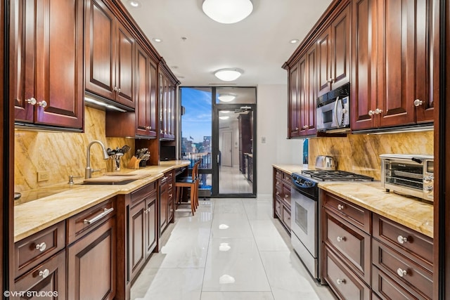 kitchen with a sink, light stone counters, backsplash, stainless steel appliances, and a toaster