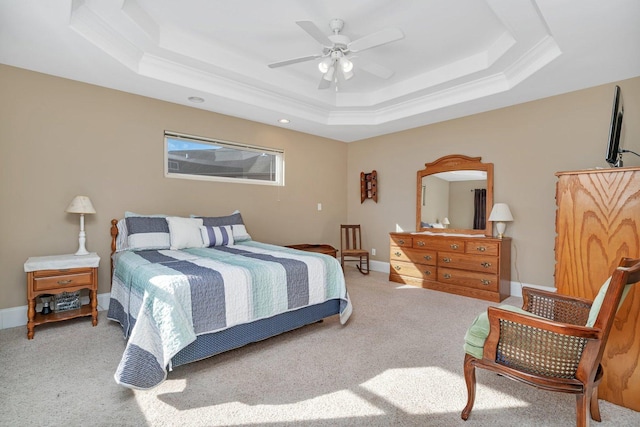 bedroom featuring a tray ceiling, baseboards, and carpet