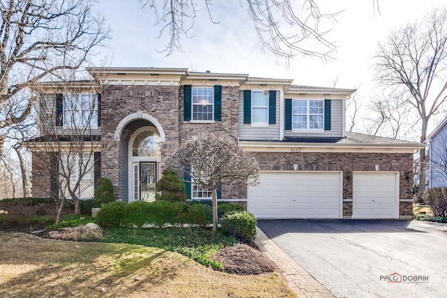 view of front of house with brick siding, aphalt driveway, and a garage