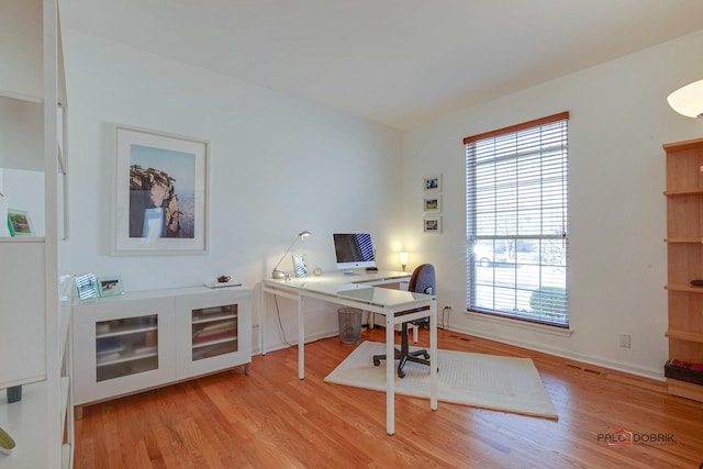 home office with visible vents, baseboards, and light wood-style floors