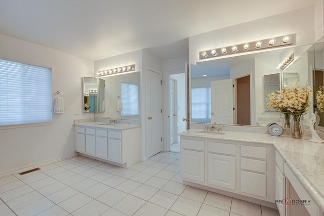 bathroom featuring a sink, plenty of natural light, two vanities, and tile patterned floors