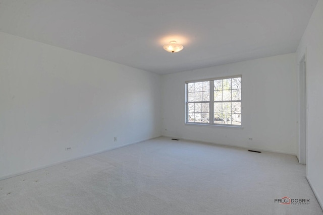 carpeted empty room featuring visible vents