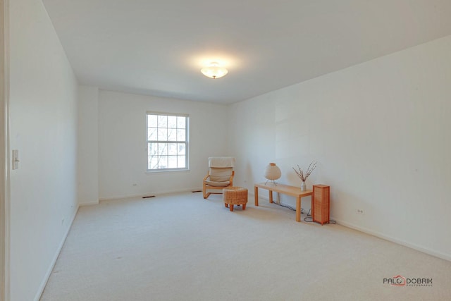 living area featuring visible vents, baseboards, and carpet