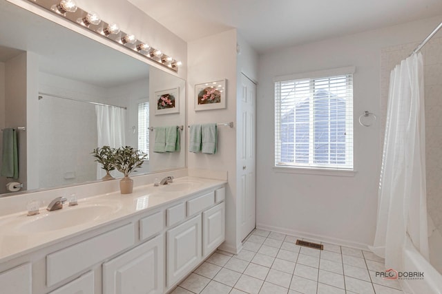 full bathroom with tile patterned flooring, visible vents, double vanity, and a sink