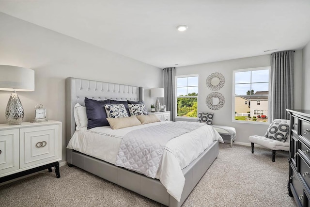 bedroom with light colored carpet and baseboards