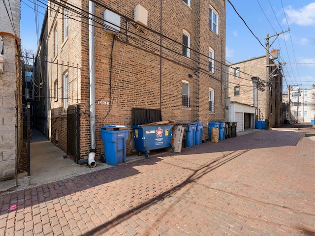 view of building exterior with decorative driveway and a garage