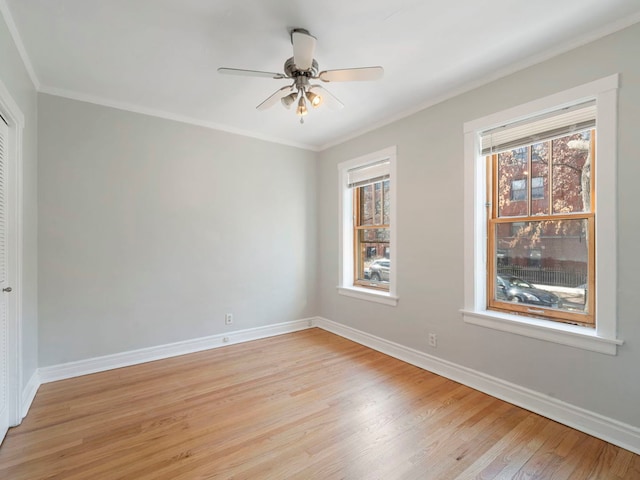 unfurnished room with baseboards, ceiling fan, crown molding, and light wood finished floors