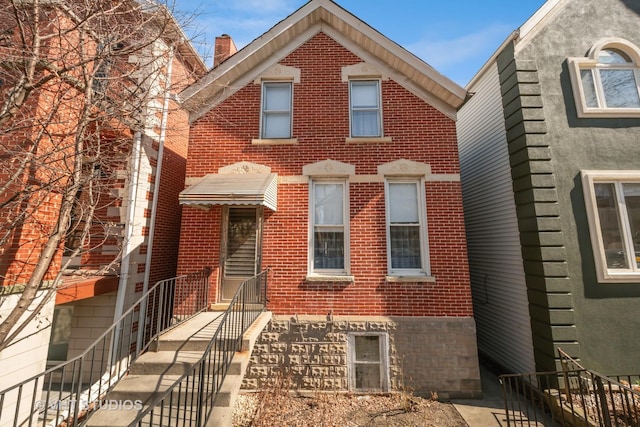 view of front of property with brick siding and a chimney