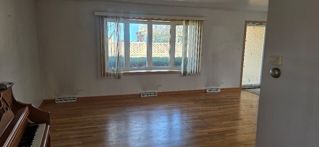 unfurnished room with visible vents and wood finished floors