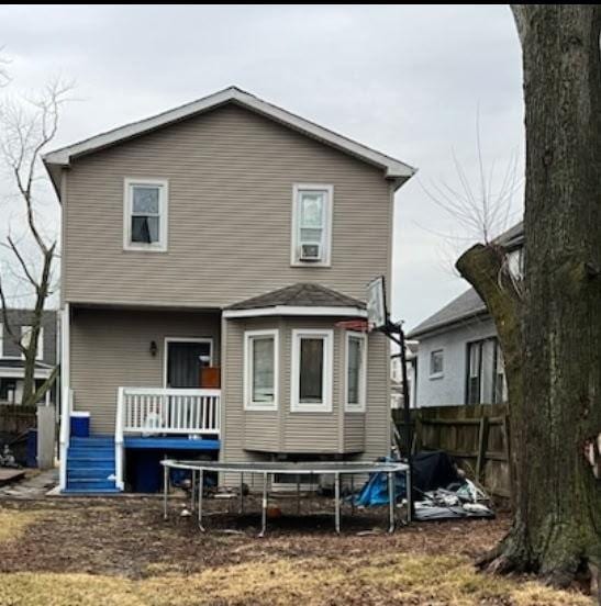 rear view of house with a deck and fence