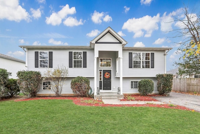 split foyer home featuring a front yard and fence